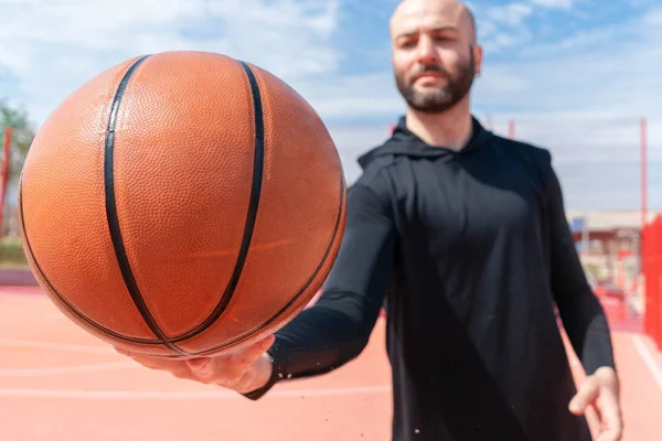 Close up of attractive man holding basket ball. Ball is on focus and foreground. — Stock Photo, Image