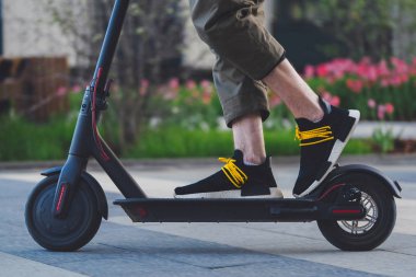 Güzel park manzara siyah elektrikli kick scooter sürme adam yakın