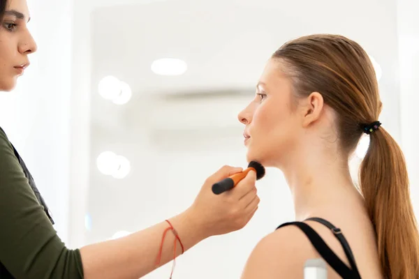 Make-up aplikuje prášek. make-up mistrovské tvářemi mladé modelky — Stock fotografie
