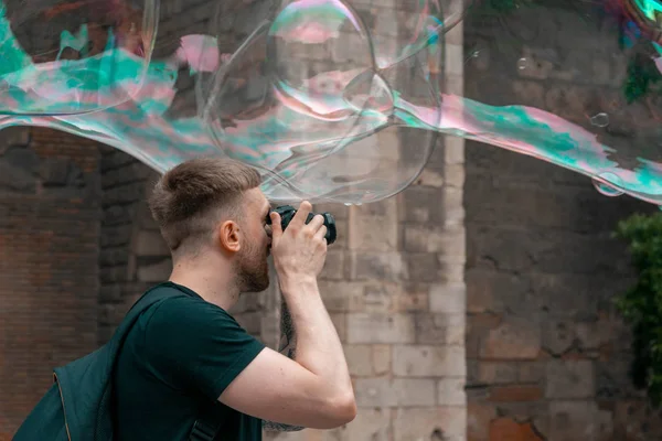 Hombre atractivo haciendo fotos de burbujas de jabón en el casco antiguo español. Blogger de viajes . — Foto de Stock