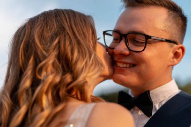 Düğün çift gün batımında parkta sevgi ve mutluluk ile birbirlerine bakıyor.