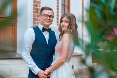 Yeni evli çift birbirine sıkıca sarılıp, birbirlerine sarılıyor. Hepsi evliliklerinden memnun..