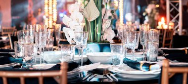 Lüks yemek servisi. Evlilik ya da yıldönümü. Ziyafet. çatal bıçak takımı, çiçek, tabak ile servis edilen masa.