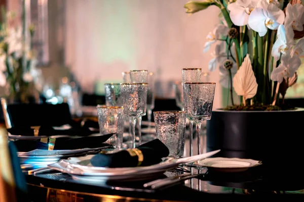 Luxus étkezés. Esküvő vagy évforduló. Bankett. asztal tálalva evőeszközökkel, virágokkal, edénykészlettel. — Stock Fotó