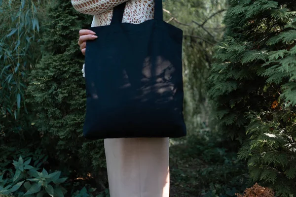 Gros plan de la femme avec sac noir vierge à l'extérieur dans le parc. Place pour l'espace vide. Espace de copie. Eco friendly . — Photo