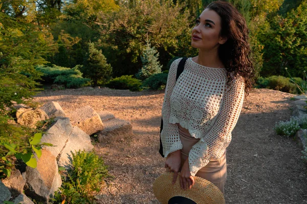 Mujer en traje romántico y sombrero de paja relajante al aire libre en el parque de otoño o verano y disfrutar del clima y la puesta de sol . —  Fotos de Stock