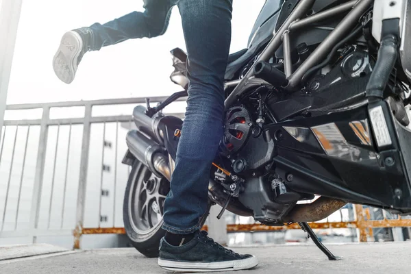 Close up de motociclista sentado em moto no fundo urbano no estacionamento . — Fotografia de Stock