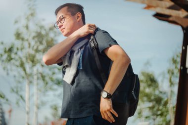 Modern parkta gezinen çekici bir adam. Adam ön planda, modern park arka planda..