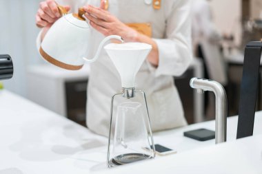 Parlak modern kafede kahve makinesinin üzerine siyah kahve dökülüyor. Kahve yapmak için alternatif yollar..