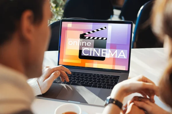 Happy Couple Watching Film or TV Series Online. Cinema Clapper With Online Cinema Inscription at Laptop Screen. Online App For Watching TV Series And Movies. Online Cinema