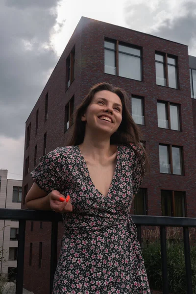 Счастливая молодая женщина без одной улыбки на фоне городского пейзажа. Согласие с самим собой, положительное — стоковое фото