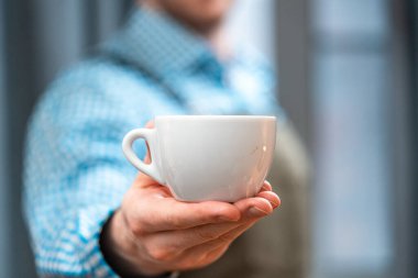 Kahve fincanı ile elini uzatan adama yaklaş. Mükemmel bir kahvaltı. Evde Kal Konsepti. Ev Mutfağında Amatör Kahve Hazırlama.