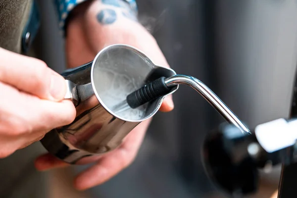 Professional Barista Warming Milk In Metal Jug With Steam Of Coffee Machine. Cappucino Or Latte Coffee Preparation by Amateur At Home.