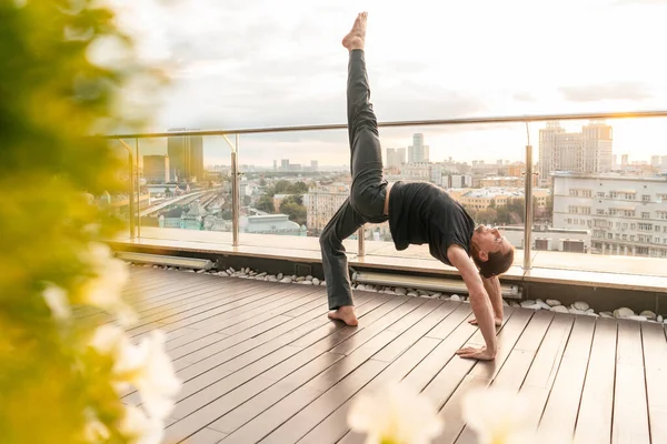 从摩天大楼到视野秀丽的商务中心，运动员们正在练习瑜伽。生意人。和平与平静的日落 — 图库照片