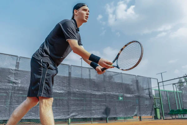 Fernplan des Menschen Tennisspieler bereitet sich darauf vor, einen Tennisball bei Match zu servieren. Spieler hält Outfit in beiden Händen, um einen Ball mit geradem Schlag zu bedienen — Stockfoto