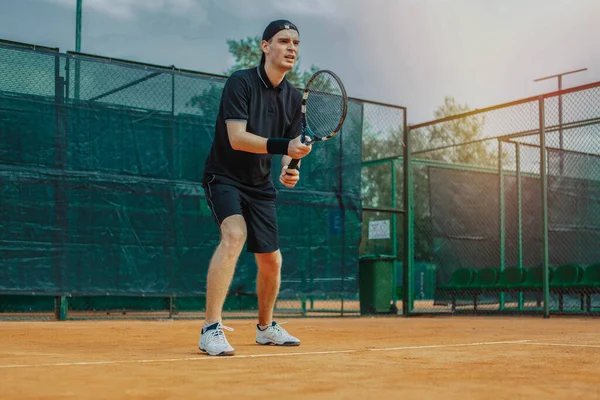 Abweichender Plan des Mannes, Schläger in beiden Händen zu halten, um den Schlag zu straffen, während er auf den Ballaufschlag auf dem Tennisplatz wartet — Stockfoto