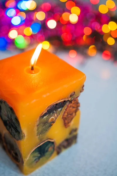 Vela colorida queimando contra o fundo das luzes do ano novo bokeh — Fotografia de Stock