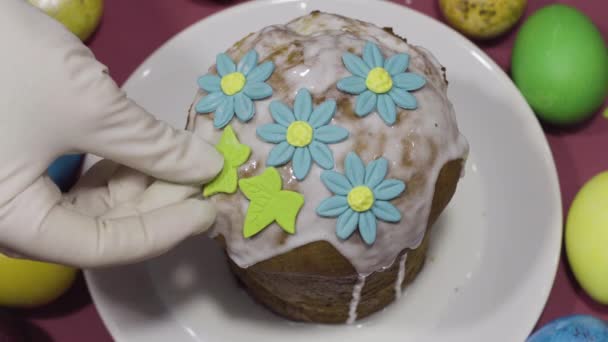 Украшение пасхальный торт с сахарными цветами и яйцами на цветном фоне — стоковое видео