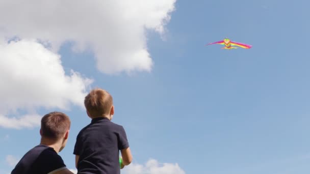 Feliz familia padre e hijo lanzando una cometa en el cielo de verano en cámara lenta — Vídeo de stock