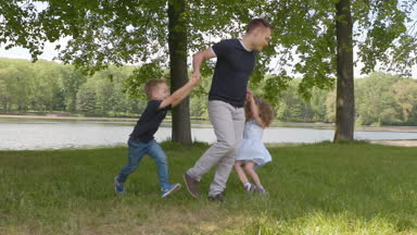 Baba oğlu ve kızı elinde yaz aylarında yavaş çekimde parkta katlanmış