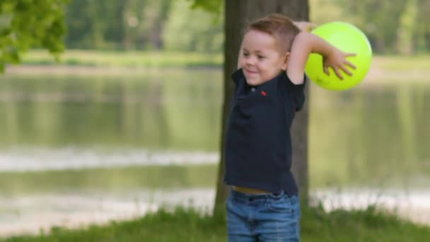 Niños jugando la pelota en el parque en cámara lenta — Vídeo de stock