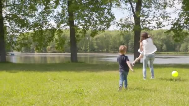 Mamma gioca con i bambini in un parco estivo al rallentatore — Video Stock
