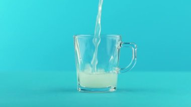 Studio kolu mavi arka plan meyve Gazlı limonata soda soğuk içecek içki pooring cam kupa ile içine yavaş hareket yakın çekim çekim yuvarlak