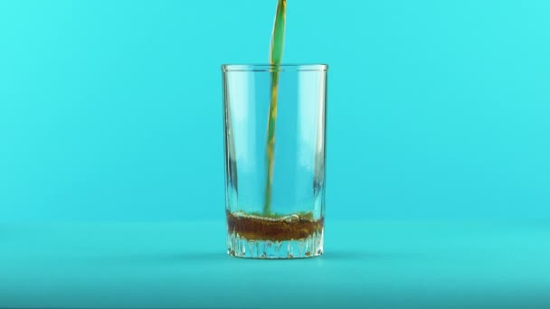 4K plan rapproché de boisson gazeuse cola soda froid braconnage en verre fileté fond bleu en studio — Video