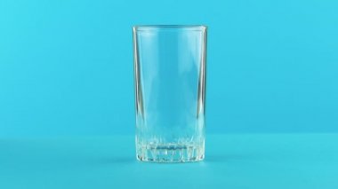 4 k yakın çekim çekim süt soğuk içecek iş parçacıklı cam mavi arka plan içine pooring studio iç.