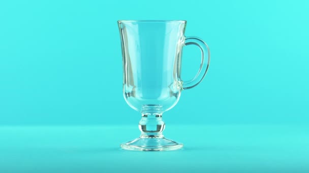 4K gros plan de fizzy cola soda boisson froide pooring dans latte verre tasse fond bleu en studio — Video