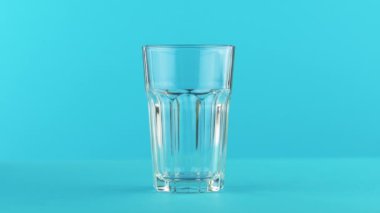 süt soğuk içecek içki pooring Studio renkli mavi zemin üzerine yönlü cam içine 4 k yakın çekim çekim