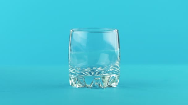 4K close-up shot of milk cold beverage drink pooring into small beautiful glass blue background in studio — Stock Video