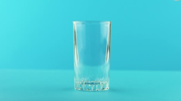 4 k κοντά shot της κίτρινο λεμόνι σόδα ανθρακούχα λεμονάδα κρύο ποτό πίνετε pooring σε φόντο μπλε με σπείρωμα γυαλί στο studio — Αρχείο Βίντεο
