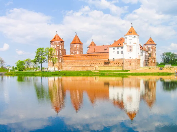 Mir, Belarus. Kale karmaşık Mir göl üzerinde güneşli gün mavi gökyüzü arka plan ile yansıtılır. Eski Ortaçağ kuleler ve unesco Dünya Kültür Mirası Listesi'ne geleneksel kaleden duvarları