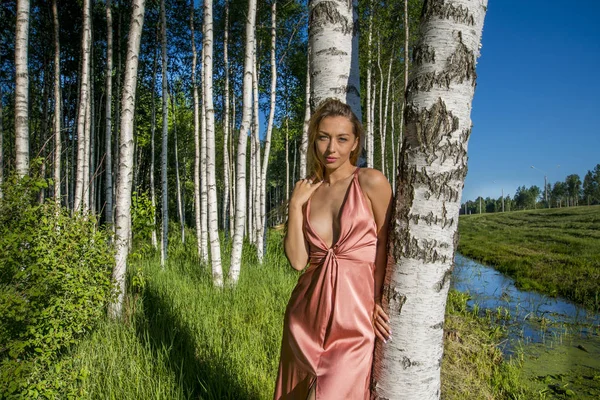 ile çekici göğüs gülümseyen bir huş ağacı koru poz uzun mercan elbiseli Genç ince güzel kız