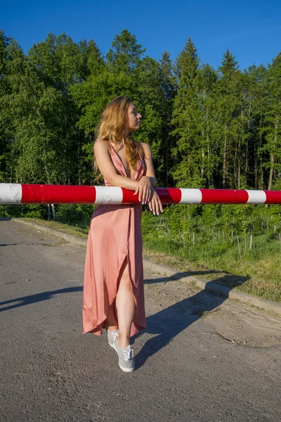 Kırmızı bariyer vogue stilini stree Fotoğrafçılık tarafından poz uzun mercan elbiseli Genç ince güzel kız