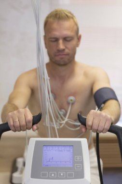 Doktor elektrokardiyogram ekipman yapım kardiyogram yükleme testi için hastane kliniğinde erkek hasta ile