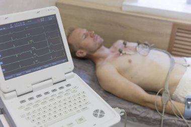 Doktor elektrokardiyogram ekipman yapım kardiyogram testine Hastanesi klinik kalp İzleyicisi'nde erkek hasta ile