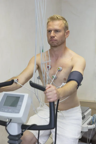 Arzt mit Elektrokardiogramm-Gerät macht Kardiogramm-Fahrradtest bei männlichem Patienten in Klinik — Stockfoto