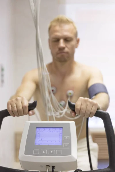 Arzt mit Elektrokardiogramm-Gerät macht Kardiogramm unter Belastungstest bei männlichem Patienten in Klinik — Stockfoto