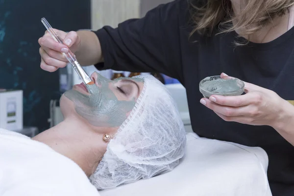 Giovane bella ragazza che riceve maschera facciale medica nel salone di bellezza spa - all'interno — Foto Stock