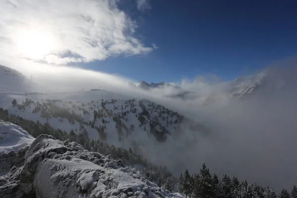 Le sommet des montagnes avec une forêt couverte de neige, de brouillard et de nuages par une journée ensoleillée et glacée — Photo