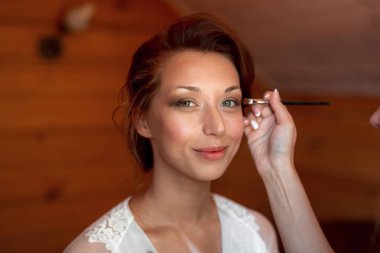 Gelin için makyaj yapma işlemi. Fırça ile çalışma modeli yüzünde makyaj sanatçısı. Güzellik salonu iç genç esmer kadın portresi