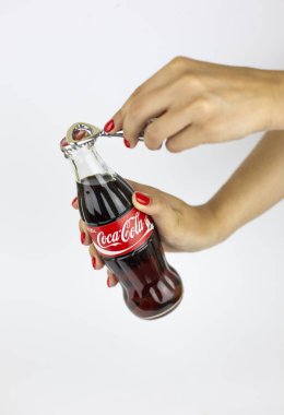 Atlanta, Georgia, Amerika Birleşik Devletleri - 22 Temmuz 2018: kadın el Kırmızı vintage tarihi kabartma cam coca-cola kontur klasik şişeden İspanya ile metal coca-cola açılış beyaz arka planda tutan çiviler