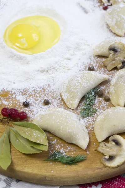 Gnocchi di cibo tradizionali russi o vareniki, pasta con carne o altro ripieno, con farina e uova serviti su un tavolo con panna acida, funghi e verdure fresche, salsa all'aglio. tradizionale — Foto Stock