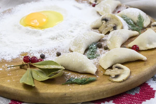 Gnocchi di cibo tradizionali russi o vareniki, pasta con carne o altro ripieno, con farina e uova serviti su un tavolo con panna acida, funghi e verdure fresche, salsa all'aglio. tradizionale — Foto Stock