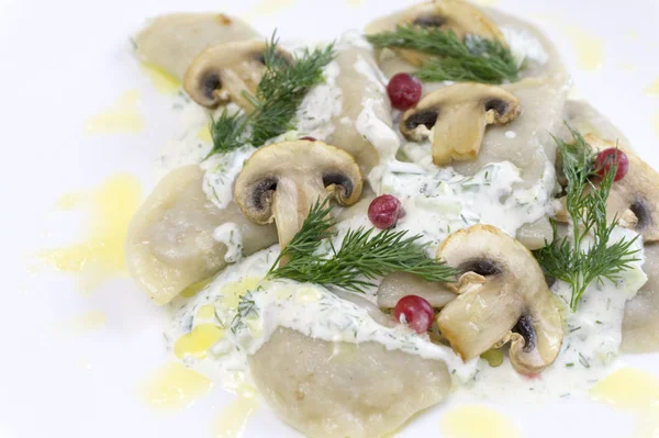 Gnocchi di cibo tradizionali russi o vareniki, pasta con carne o altro ripieno, con farina e uova serviti su un tavolo con panna acida, funghi e verdure fresche, salsa all'aglio. tradizionale — Foto Stock