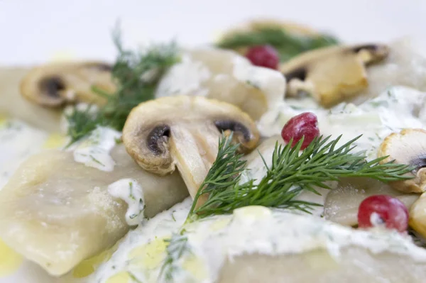 Gnocchi di cibo tradizionali russi o vareniki, pasta con carne o altro ripieno, con farina e uova serviti su un tavolo con panna acida, funghi e verdure fresche, salsa all'aglio. tradizionale — Foto Stock