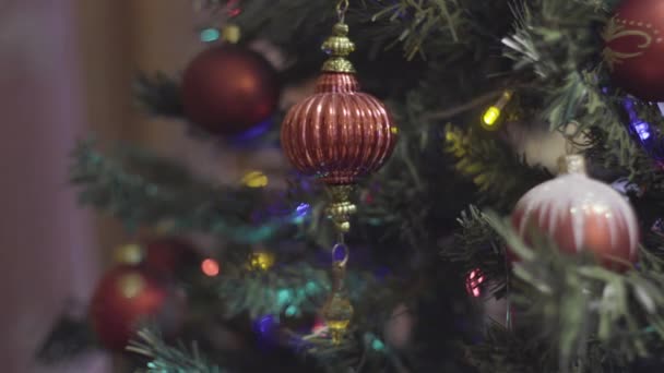 Vintage Weihnachtsspielzeug schaukelnde Weihnachts- und Neujahrsdekoration. abstrakte verschwommene Bokeh-Urlaubshintergrund. Blinkende Girlanden. Weihnachtsbaumbeleuchtung funkelt. — Stockvideo