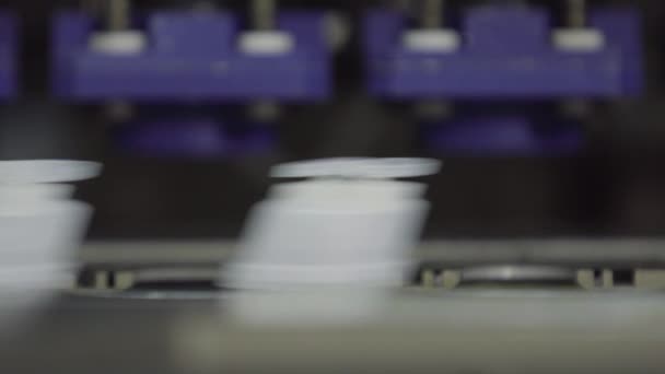Installatie van caps op gesteriliseerde plastic flessen met geneeskunde op de transportband van de fabriek voor de productie van medische producten en geneesmiddelen met klap vulling zegel tecnology — Stockvideo
